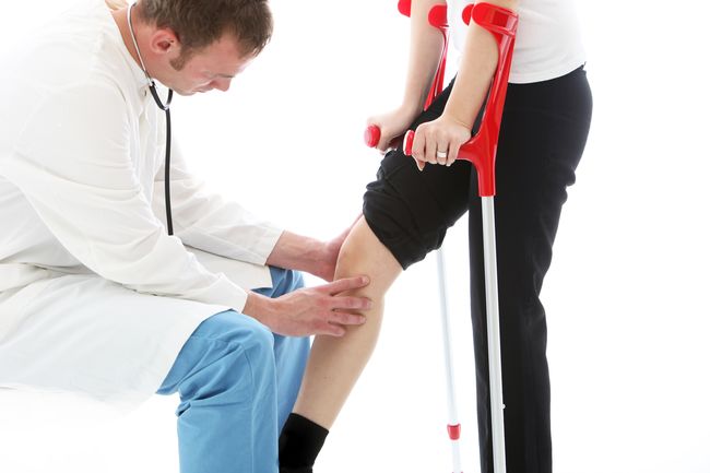 Orthopaedic surgeon examining woman's knee